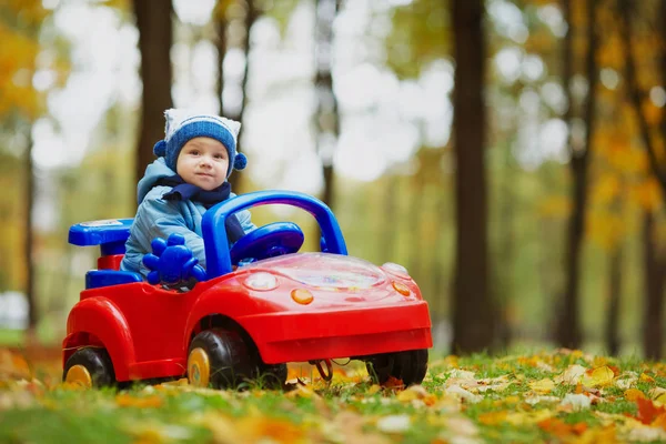 Pequeno engraçado menino condução brinquedo carro — Fotografia de Stock