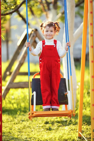 Happy little girl on swings — Stock Photo, Image