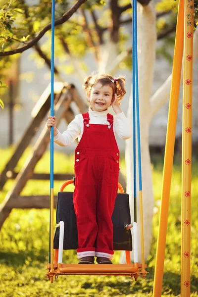 Feliz niña en columpios — Foto de Stock