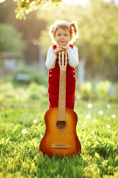 Söt liten flicka med gitarr — Stockfoto