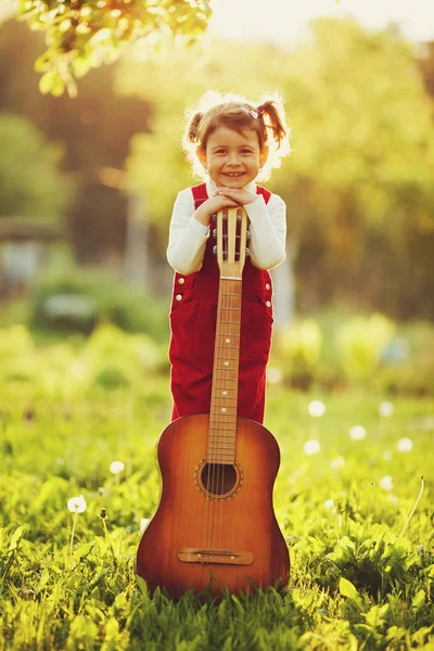 Милая маленькая девочка с гитарой — стоковое фото