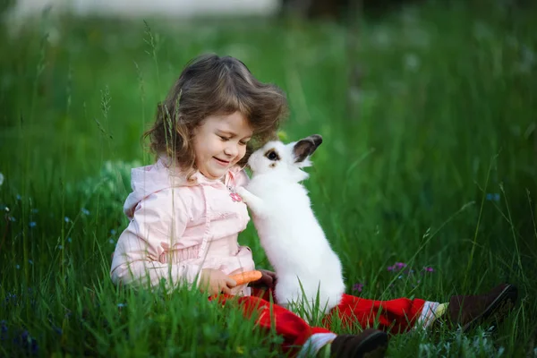 Милая маленькая девочка с белым кроликом — стоковое фото