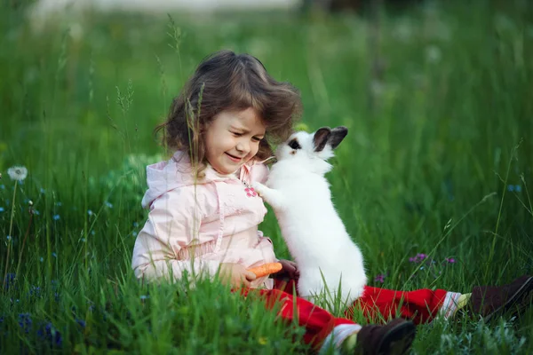 Милая маленькая девочка с белым кроликом — стоковое фото