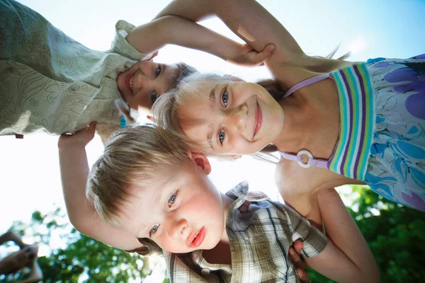 Glada barn kramas underifrån — Stockfoto
