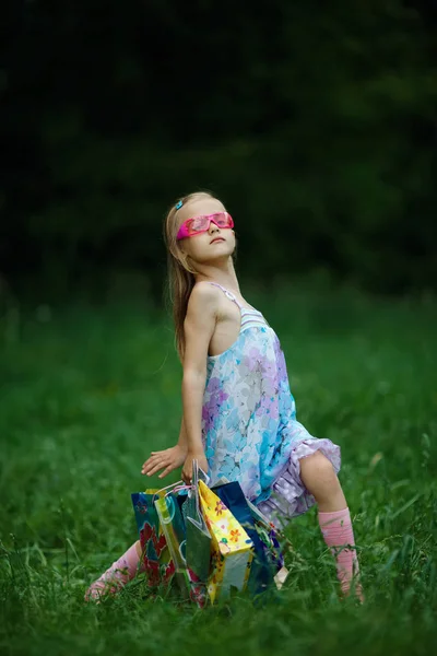 Menina com sacos de compras no parque de verão — Fotografia de Stock