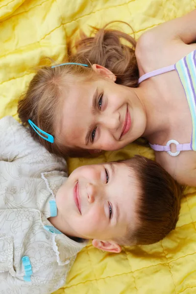 Симпатичные мальчик и девочка лежат на одеяле — стоковое фото