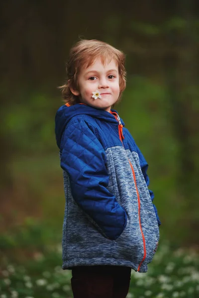 Kleiner Junge im Frühlingswald mit vielen Blumen — Stockfoto