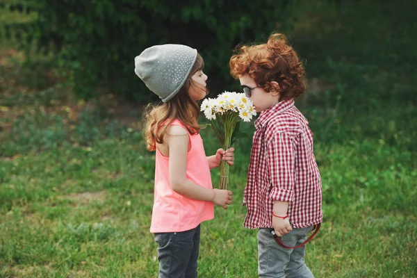 Dos lindos hipsters huelen las flores — Foto de Stock