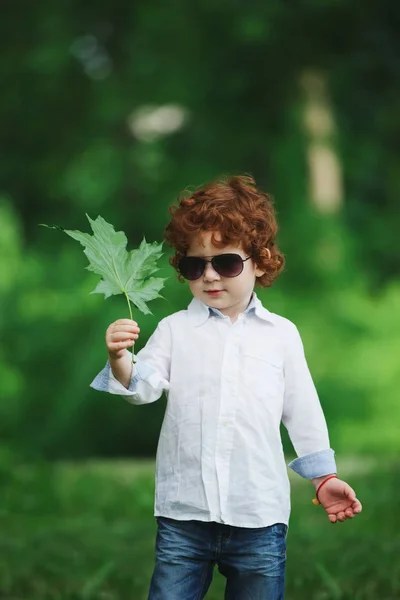 Pequeno menino moderno na grama — Fotografia de Stock