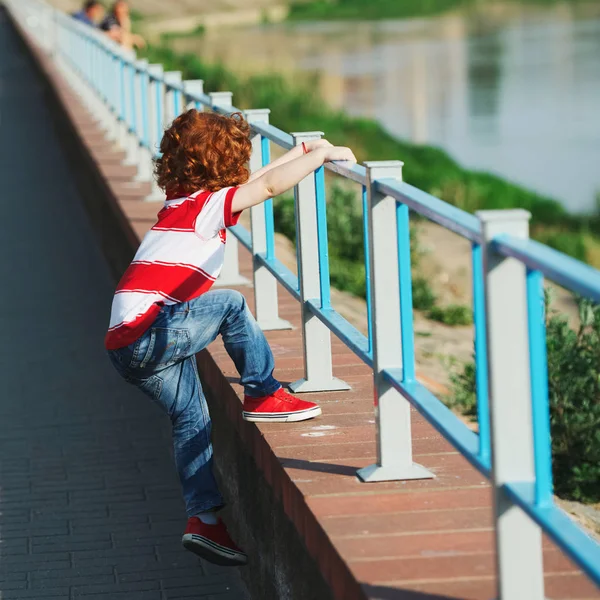 little boy climbing over the fence