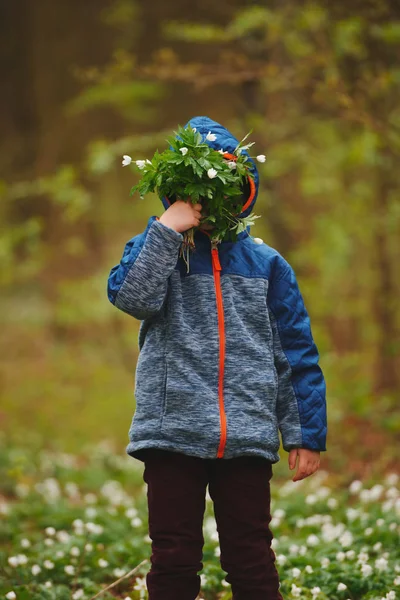 Niño pequeño en el bosque de primavera con muchas flores —  Fotos de Stock