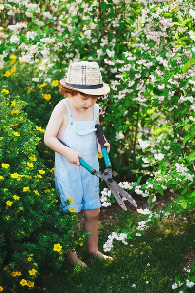 Bambino che innaffia il giardino con il tubo — Foto Stock