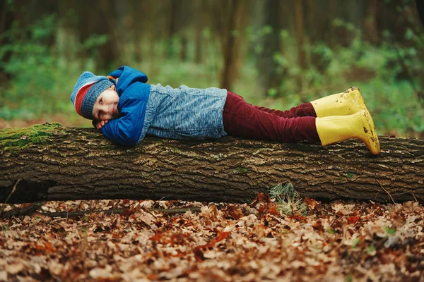 Liten rolig pojke på stora loggar — Stockfoto