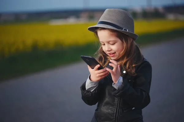 Маленька смішна дівчинка зі смартфоном — стокове фото