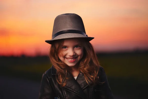 Liten flicka med hatt på kvällen sunset — Stockfoto