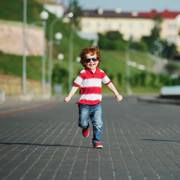 Happy little boy walking on the street — Stock Photo, Image