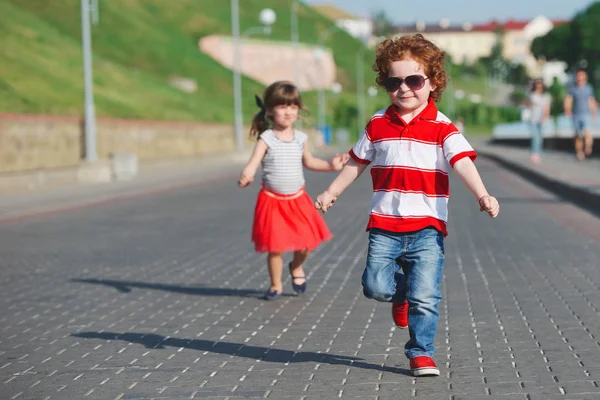 Zwei glückliche Kinder rennen auf der Promenade — Stockfoto