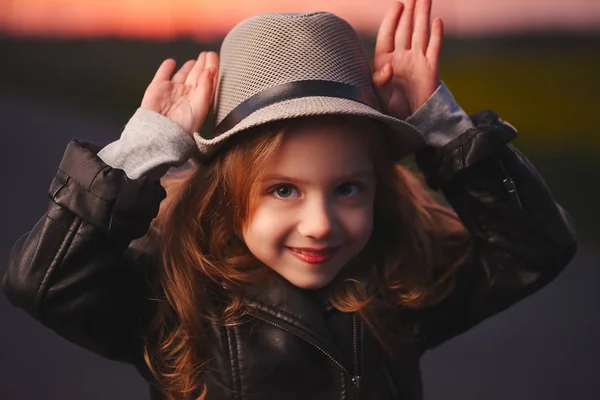 Маленька дівчинка з капелюхом на вечірньому заході сонця — стокове фото