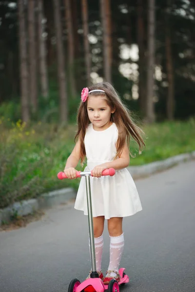 滑板车在道路上的漂亮女孩 — 图库照片