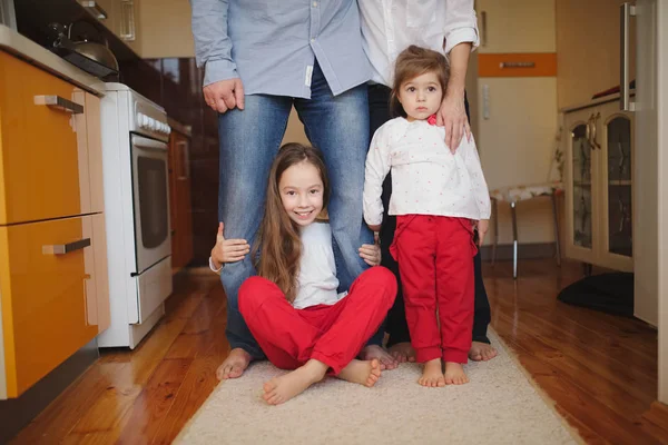 Petites filles étreignant maman et papa pour les jambes — Photo