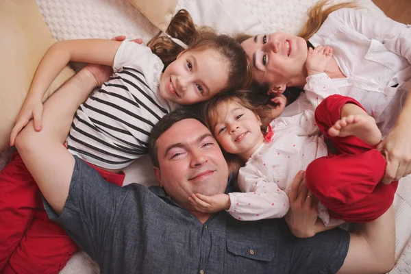 Giovane famiglia sdraiata a letto a casa — Foto Stock