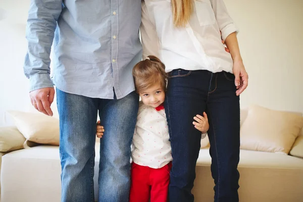 Girl hugging mom and dad for legs — Stock Photo, Image