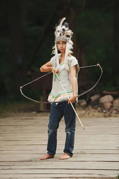 Kleiner lustiger Junge spielt Indianer — Stockfoto