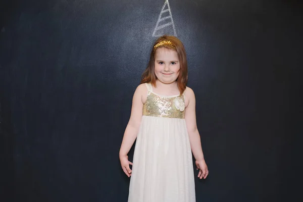 Niña divertida con sombrero de cumpleaños en pizarra —  Fotos de Stock