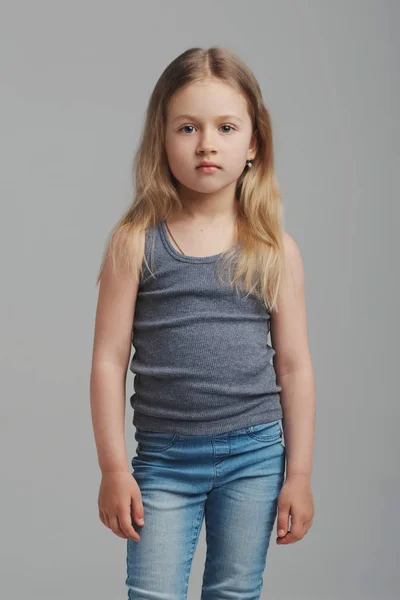 Pequena menina estúdio retrato no fundo cinza — Fotografia de Stock