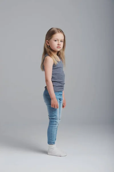 灰色の背景に小さな少女のスタジオ ポートレート — ストック写真