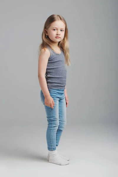 灰色の背景に小さな少女のスタジオ ポートレート — ストック写真