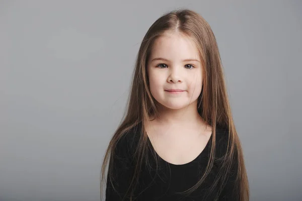 Pequena menina estúdio retrato no fundo cinza — Fotografia de Stock