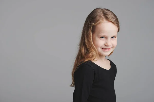 Pequena menina estúdio retrato no fundo cinza — Fotografia de Stock