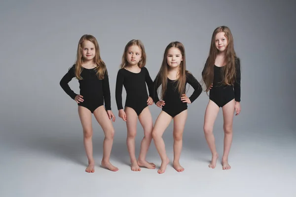 Cuatro hermosas modelos jóvenes en gris — Foto de Stock
