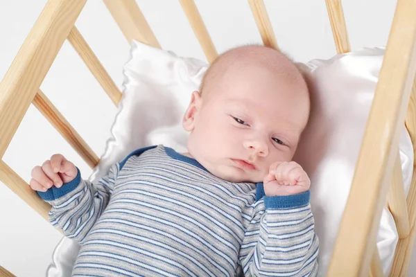 Bebê recém-nascido bonito na cama de madeira — Fotografia de Stock