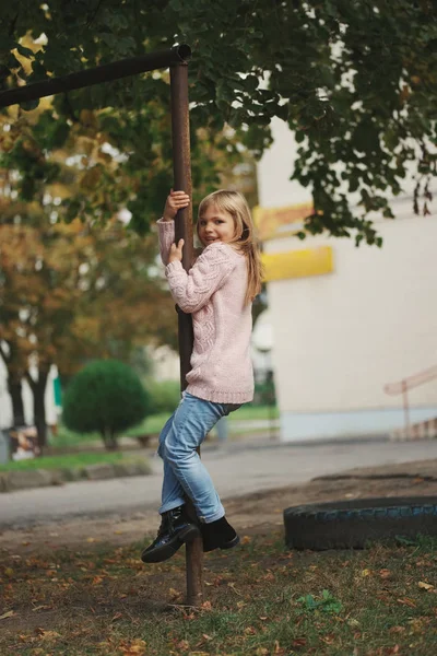 Joven feliz chica balanceo en el travesaño — Foto de Stock