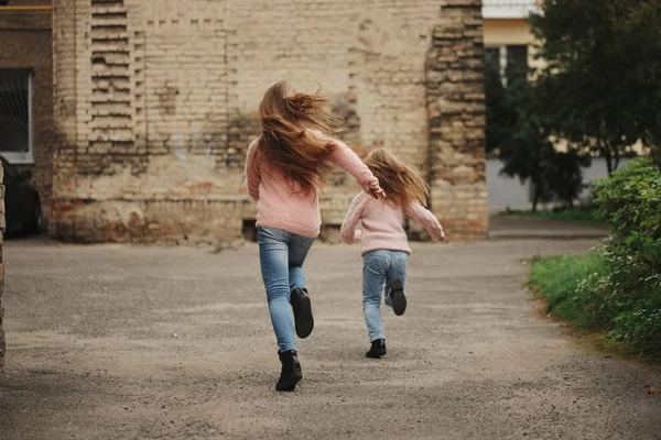 Duas meninas com cabelos longos fugindo — Fotografia de Stock