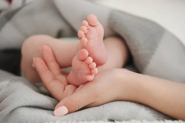 Matka drží nohy miminka — Stock fotografie