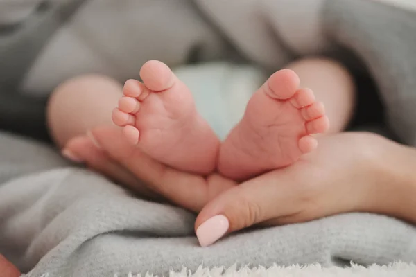 Mãe segurando seus pés bebês — Fotografia de Stock