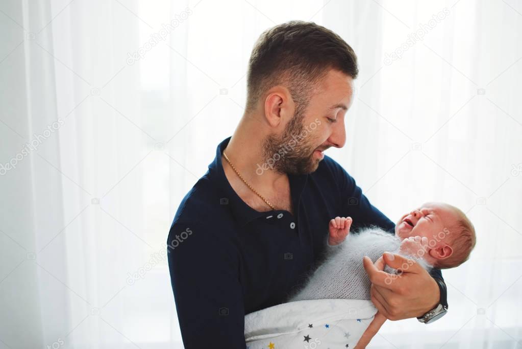 father with cute crying newborn baby
