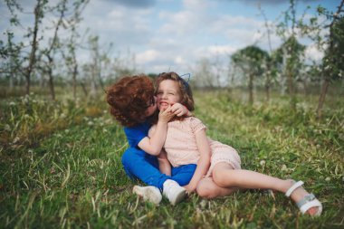 küçük erkek ve kız çiçek açan bahçesinde