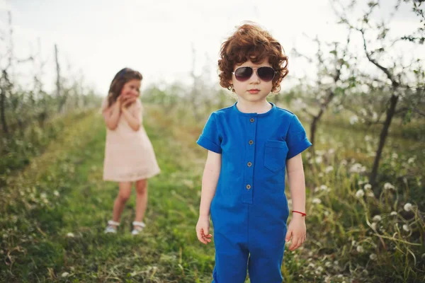 小男孩和女孩在盛开的花园里 — 图库照片