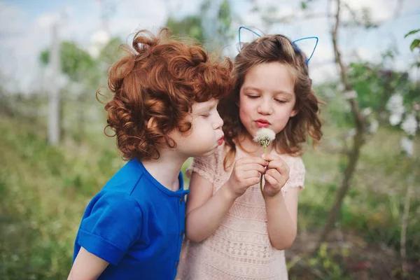 Mały chłopiec i dziewczynka w kwitnący ogród — Zdjęcie stockowe