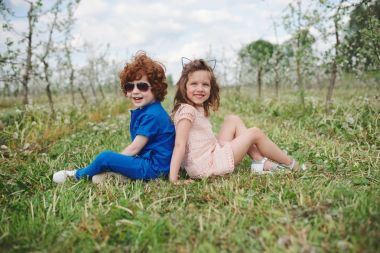 küçük erkek ve kız çiçek açan bahçesinde