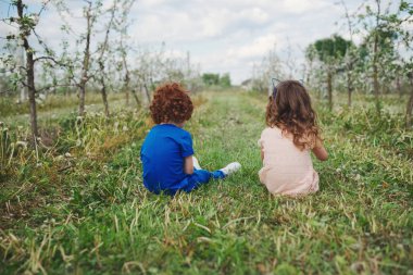 küçük erkek ve kız çiçek açan bahçesinde