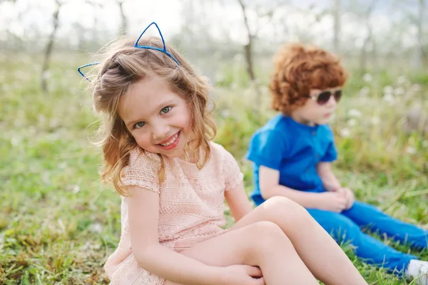 Little boy and girl in blooming garden — Stock Photo, Image