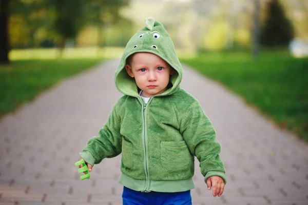 Pequeno menino infeliz com traje de dinossauro — Fotografia de Stock