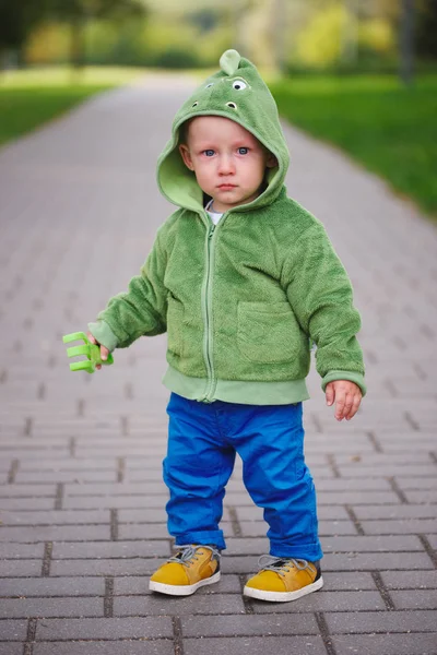 Pequeno menino infeliz com traje de dinossauro — Fotografia de Stock