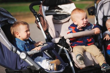 komik çocuk strollers parkta oturan