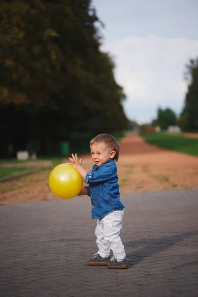 Happy little boy playing with yellow ball — Stock Photo, Image